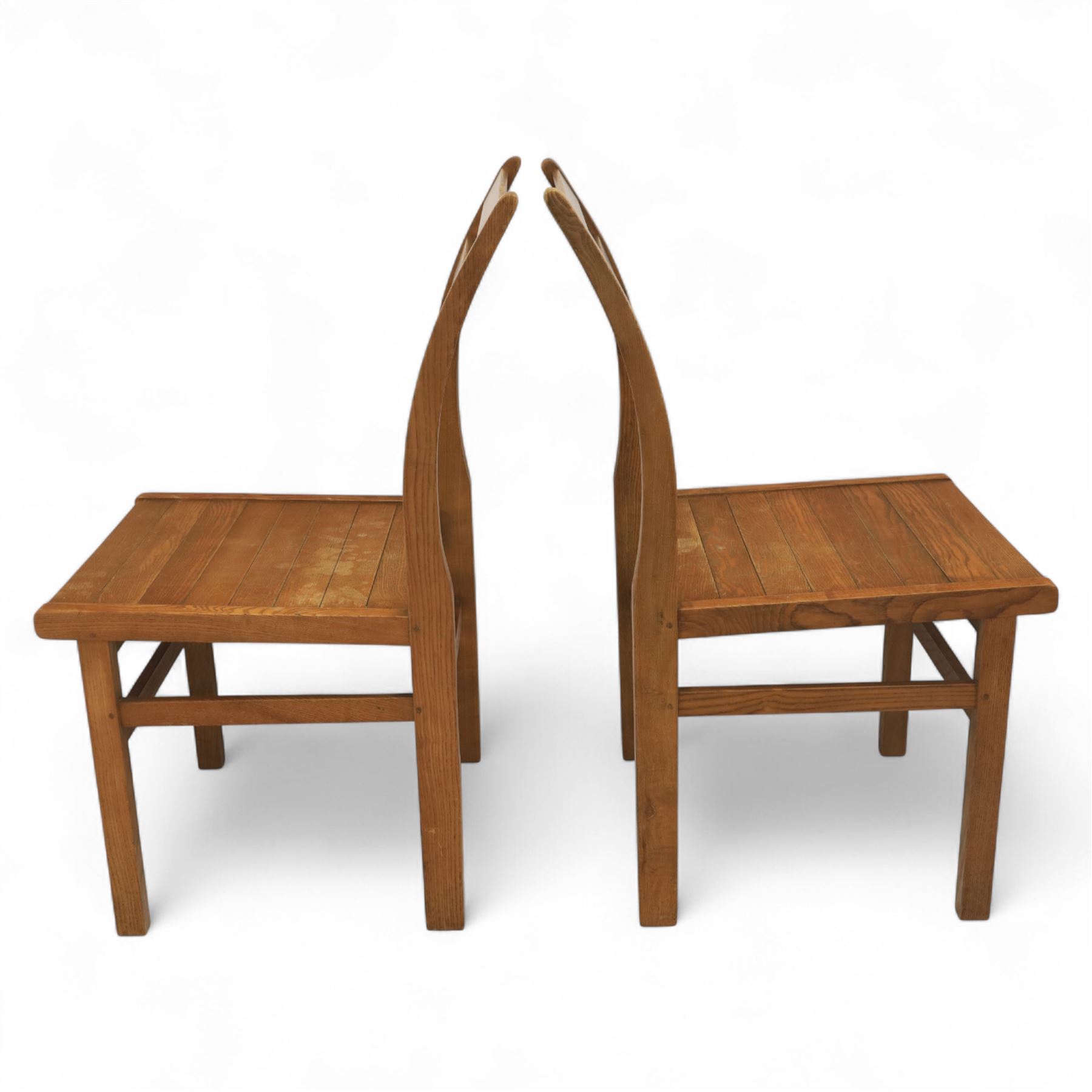 Treske of Thirsk - solid oak refectory dining suite, rectangular top with chamfered edge over trestle base united by a central stretcher, together with six matching slat back dining chairs, including two carvers, with panelled seats and square legs united by stretchers (H 87cm, W 62cm, D 57cm)