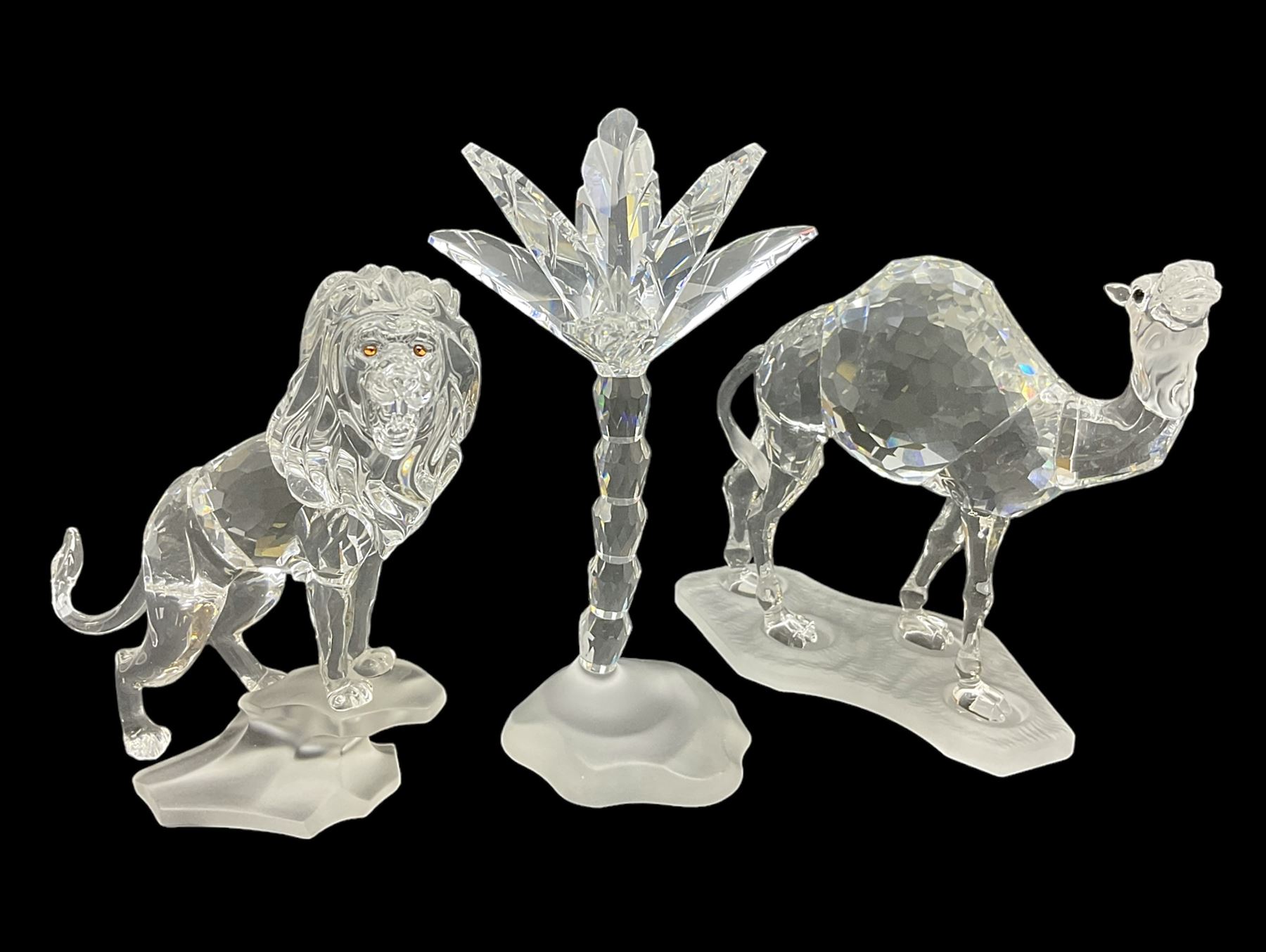 Swarovski Crystal animals, comprising camel and lion, both upon frosted crystal bases, together with Swarovski Crystal palm tree, upon similar frosted crystal base, tallest H14cm