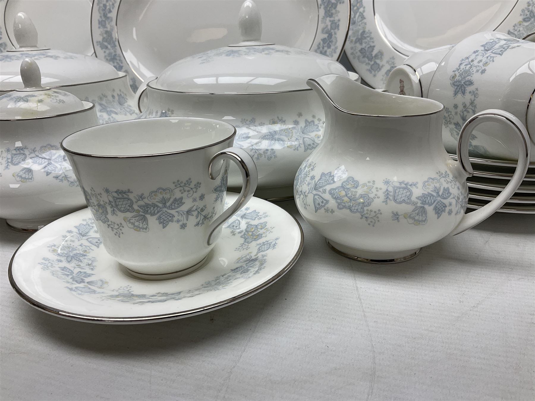 Royal Doulton tea and dinner wares in the Meadow Mist pattern, no H5007, comprising seven dinner plates, eight side plates, two lidded tureens, two jugs, lidded sucrier, oval serving dish, six teacups, seven saucers, seven tea plates and large saucer