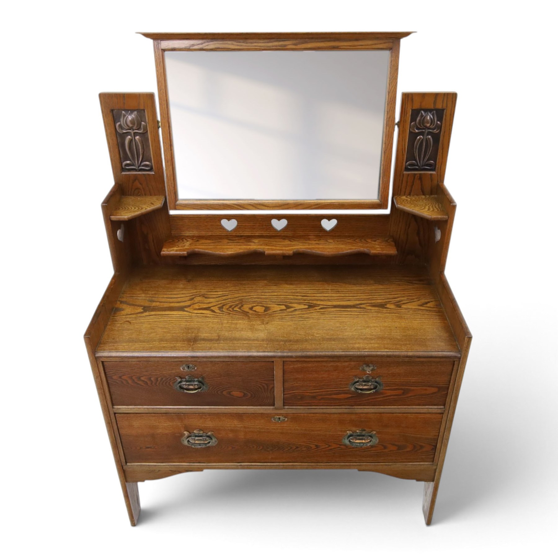 Shapland & Petter - oak mirrored dressing chest, tilted mirror flanked by tulip carved supports, shaped shelves with heart cut outs, above two short over one long drawers, with brass handles and stamped S & P on the locks, raised on shaped supports