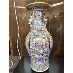 Large pair of 19th century Cantonese famille rose vases, each painted with various courtly scenes, including a display of warriors fighting on horseback before an official and his attendants, double Buddhist lion handles and applied at the shoulders with chilong, the lower band painted with Greek key motif, H58cm (2)