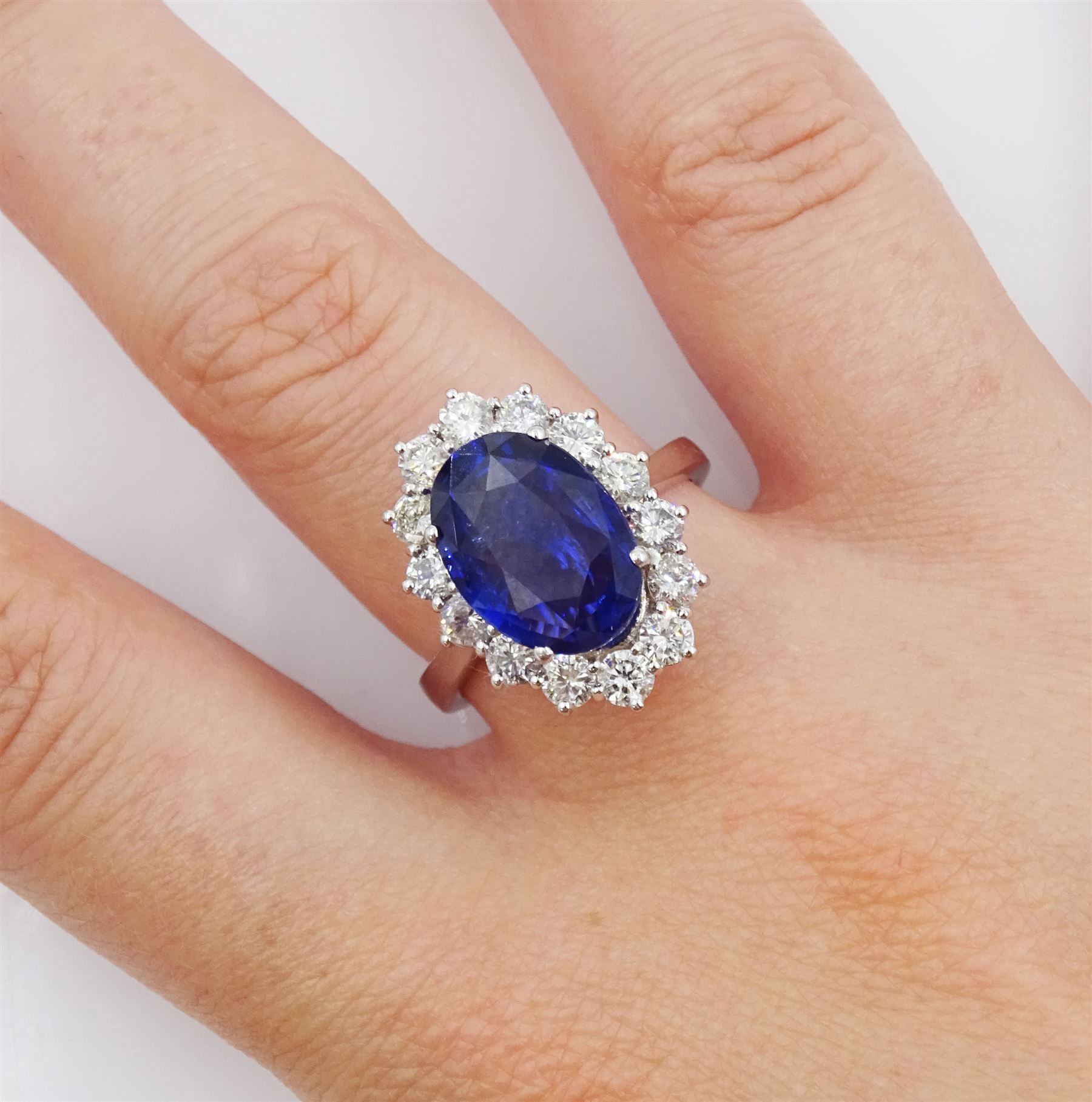 18ct white gold oval sapphire and round brilliant cut diamond cluster ring, hallmarked, sapphire approx 3.50 carat, total diamond weight approx 0.90 carat