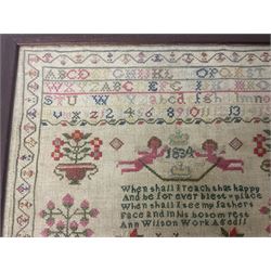 William IV sampler worked by Ann Wilson, depicting bands of alphabet and numbers above date of 1834, and verse detailed 'When shall I reach that happy And be for ever blest place When shall I see my fathers Face and in his bosom rest Ann Wilson Work Aged 11', amidst various motifs including putti, stag, and flowering urns, within a foliate border, framed and glazed, overall H44cm W41cm