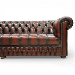 Late 20th century four seat Chesterfield sofa, upholstered in deep buttoned brown leather, with rolled arms, buttoned back and seat, studded detailing and squat feet