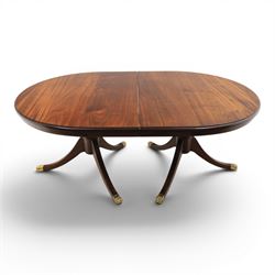 Regency design mahogany extending twin pedestal dining table with two additional leaves, raised on splayed supports terminating brass paw feet
Extends to 268cm