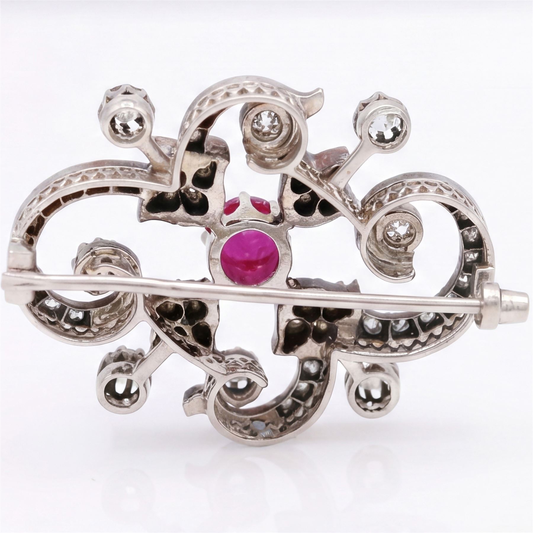 19th century French 18ct white gold ruby and diamond brooch by Eugène Fontenay, centrally set with a single cabochon cut ruby of approx 1.85 carat, the foliate scroll border set with eight old cut diamonds of approx 1.45 carat and rose cut diamonds, stamped with makers mark EF, eagles head and numbered 23960