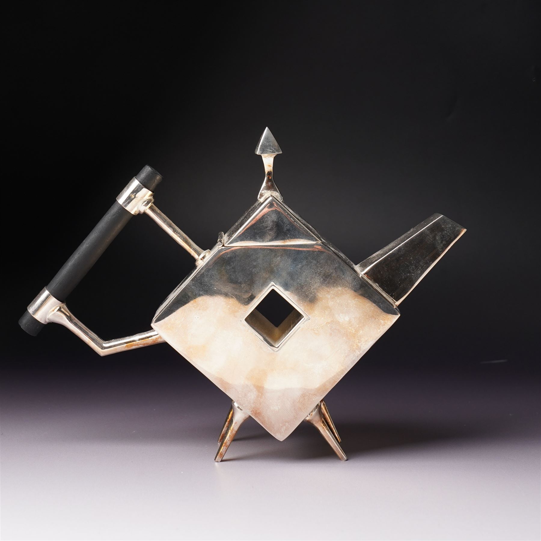 Manner of Christopher Dresser (1834-1904) - two art deco design silver plated teapots, of circular and square form with vacant centre, ebonised handles, each marked and with registration mark, max H18cm (2)