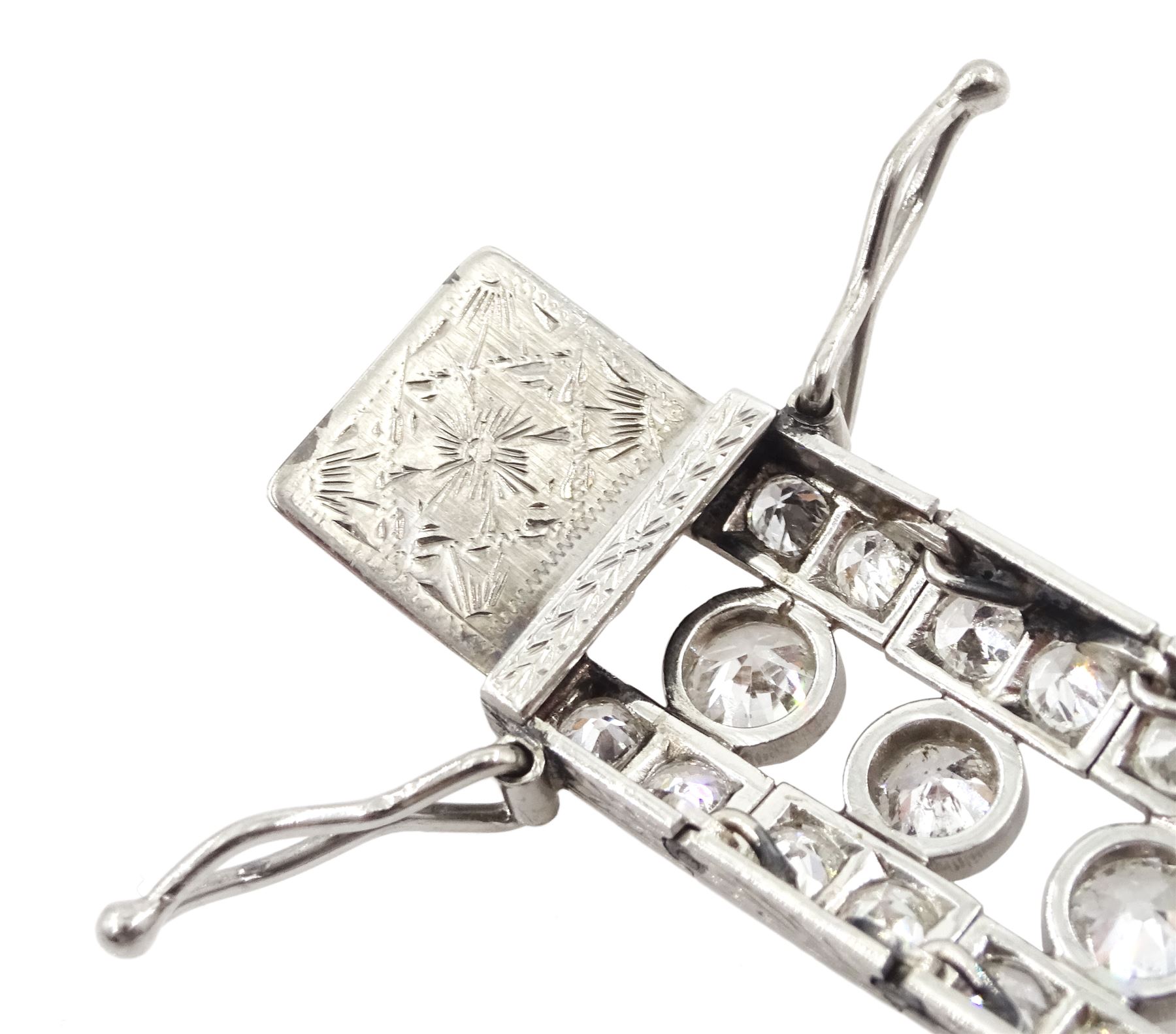 Continental Art Deco platinum old cut diamond openwork bracelet, circa 1920's, twenty-two bezel set graduating diamonds of approx 9.45 carat, the principal diamond approx 0.90, with a row milgrain set diamonds either side, the clasp set with a single diamond, the bracelet sides and clasp with engraved foliate decoration, total diamond weight approx 20.60 carat