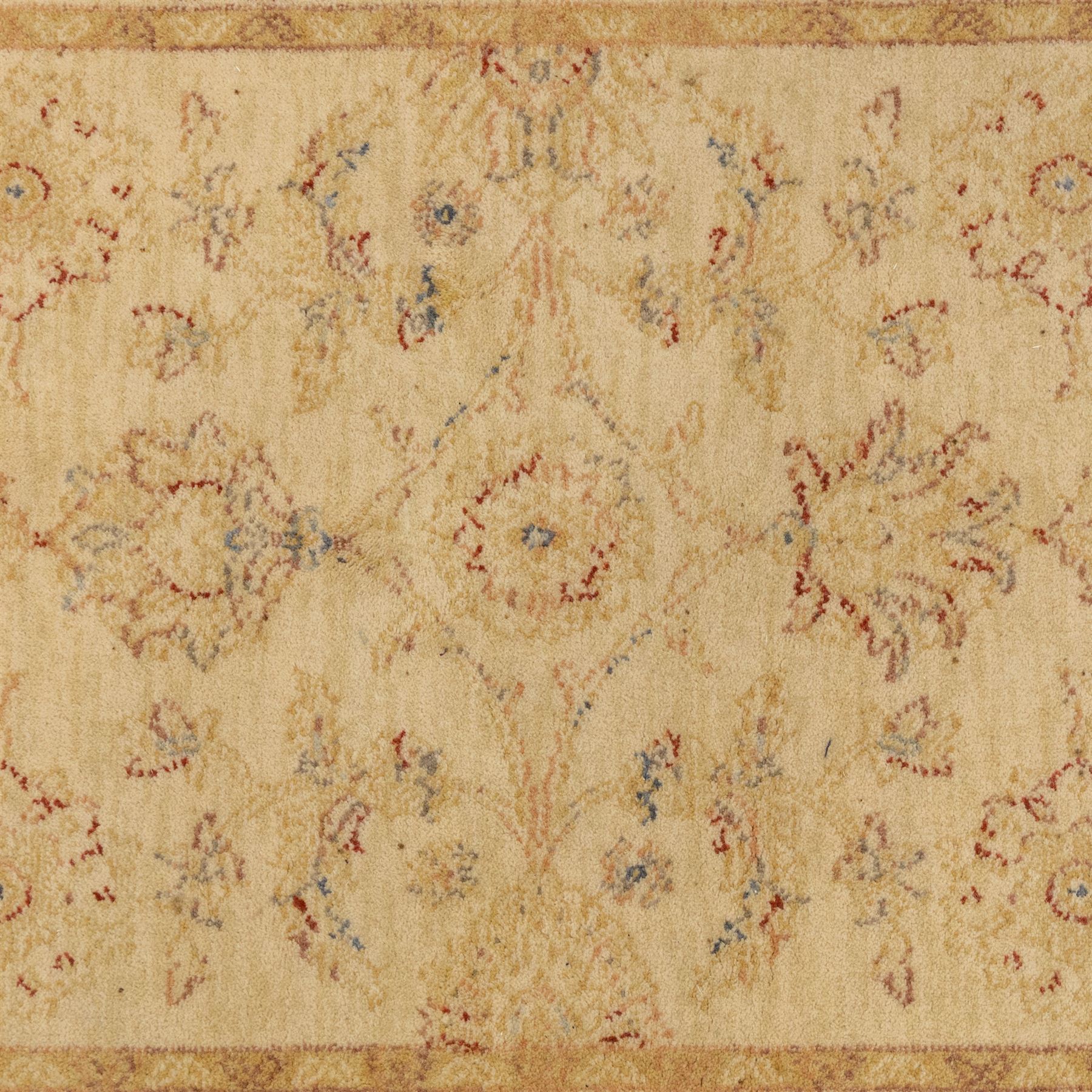 Cream ground wool rug, with faded floral medallion and scrolling foliate design, enclosed by matching floral border in beige, soft red and blue tones