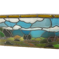 Stained and leaded glass window pane, depicting country side scene with trees and church