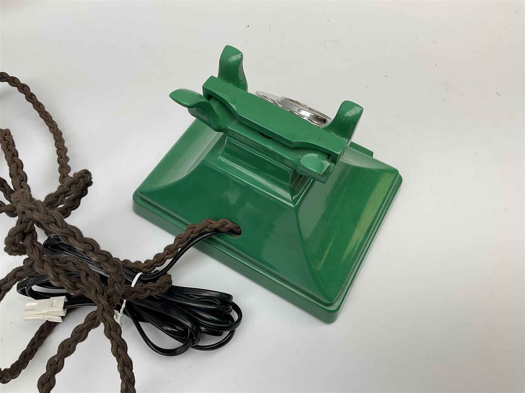 Jade green Bakelite telephone, of pyramid form with rotary alphabet dial, brown braided handset cord and a base draw, W18cm D14cm H15cm