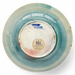 William Moorcroft plate decorated with the leaves and berries pattern, with signature mark and 'Potter to H.M. the Queen' to base, with stand, D29cm