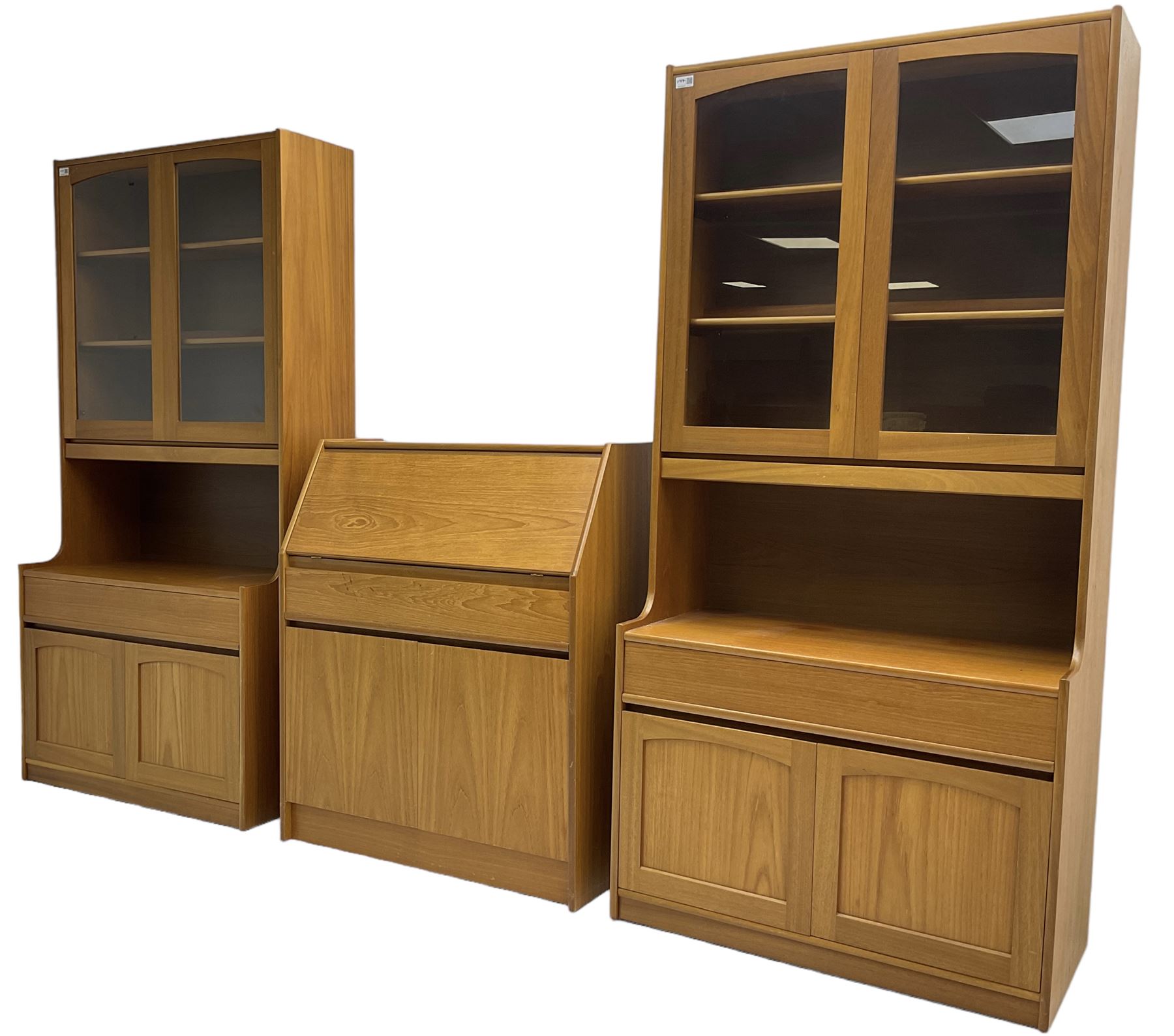 Sutcliffe of Todmorden - pair of teak wall units, fitted with two glazed doors over drawer and double cupboard (W86cm, D45cm, H198cm); and a matching fall front bureau (W84cm, D41cm, H100cm)