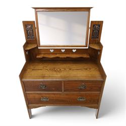 Shapland & Petter - oak mirrored dressing chest, tilted mirror flanked by tulip carved supports, shaped shelves with heart cut outs, above two short over one long drawers, with brass handles and stamped S & P on the locks, raised on shaped supports