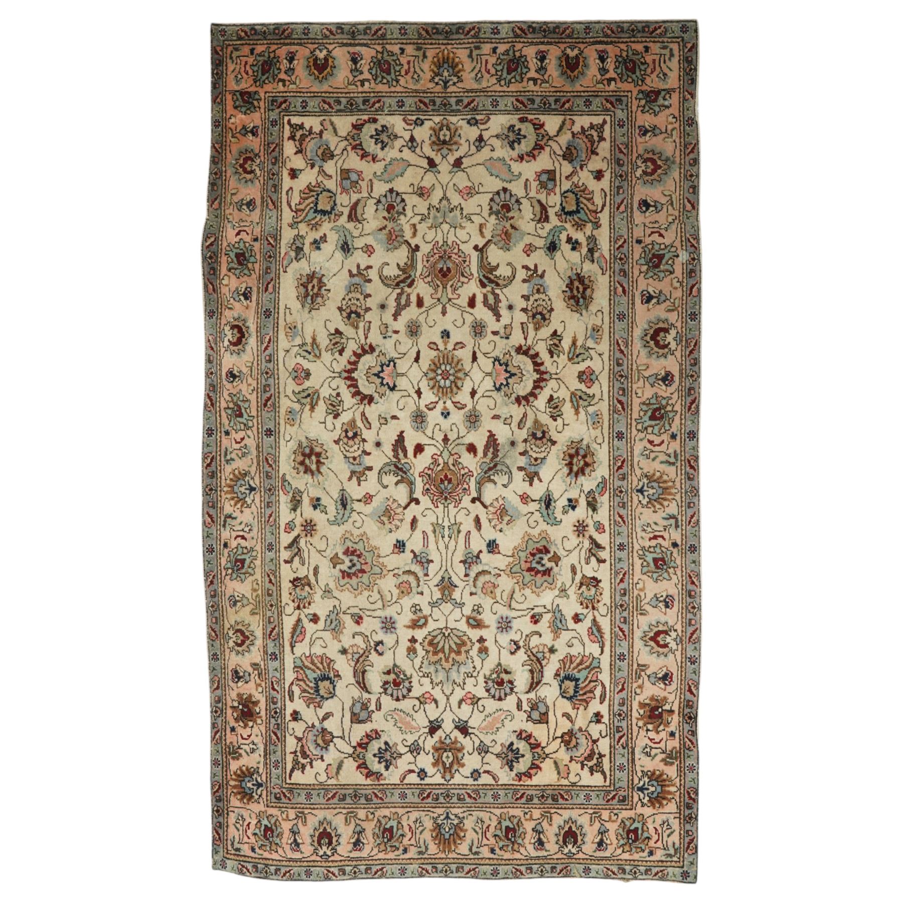 Persian Kashan rug, ivory ground field decorated with an all-over design of scrolling vines and stylized palmettes in pastel tones and conforming floral borders