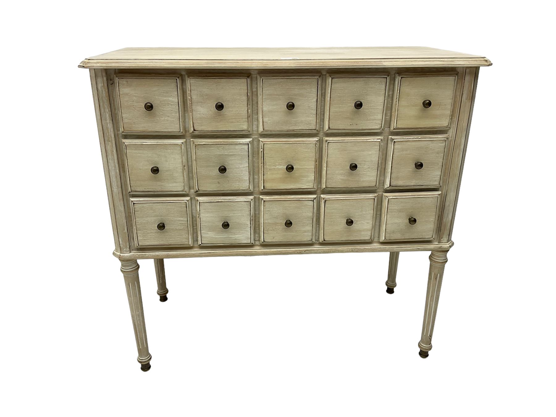 Washed finish pigeon hole or apothecary style chest, fitted with fifteen drawers, raised on fluted tapered supports 