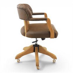 Captain's swivel desk chair upholstered in buttoned tan leather, button backed chair rail, padded and downswept arms, raised on a six point base with castors