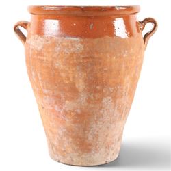 Spanish terracotta twin handled olive jar, of typical baluster form with orange glaze deco...