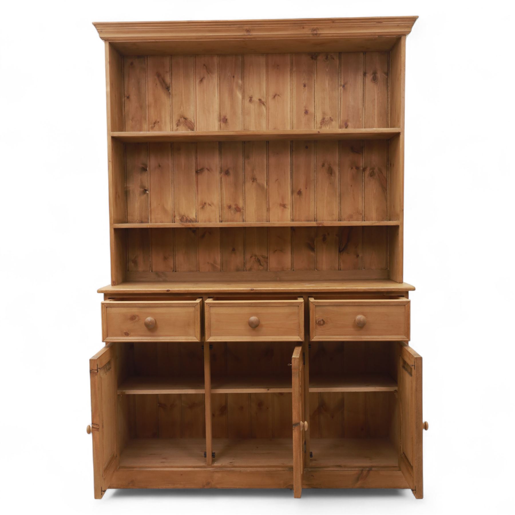 Late 20th century pine kitchen dresser, the upper section with open shelves and tongue and groove back, over a triple cupboard base with three drawers, turned wooden knobs throughout