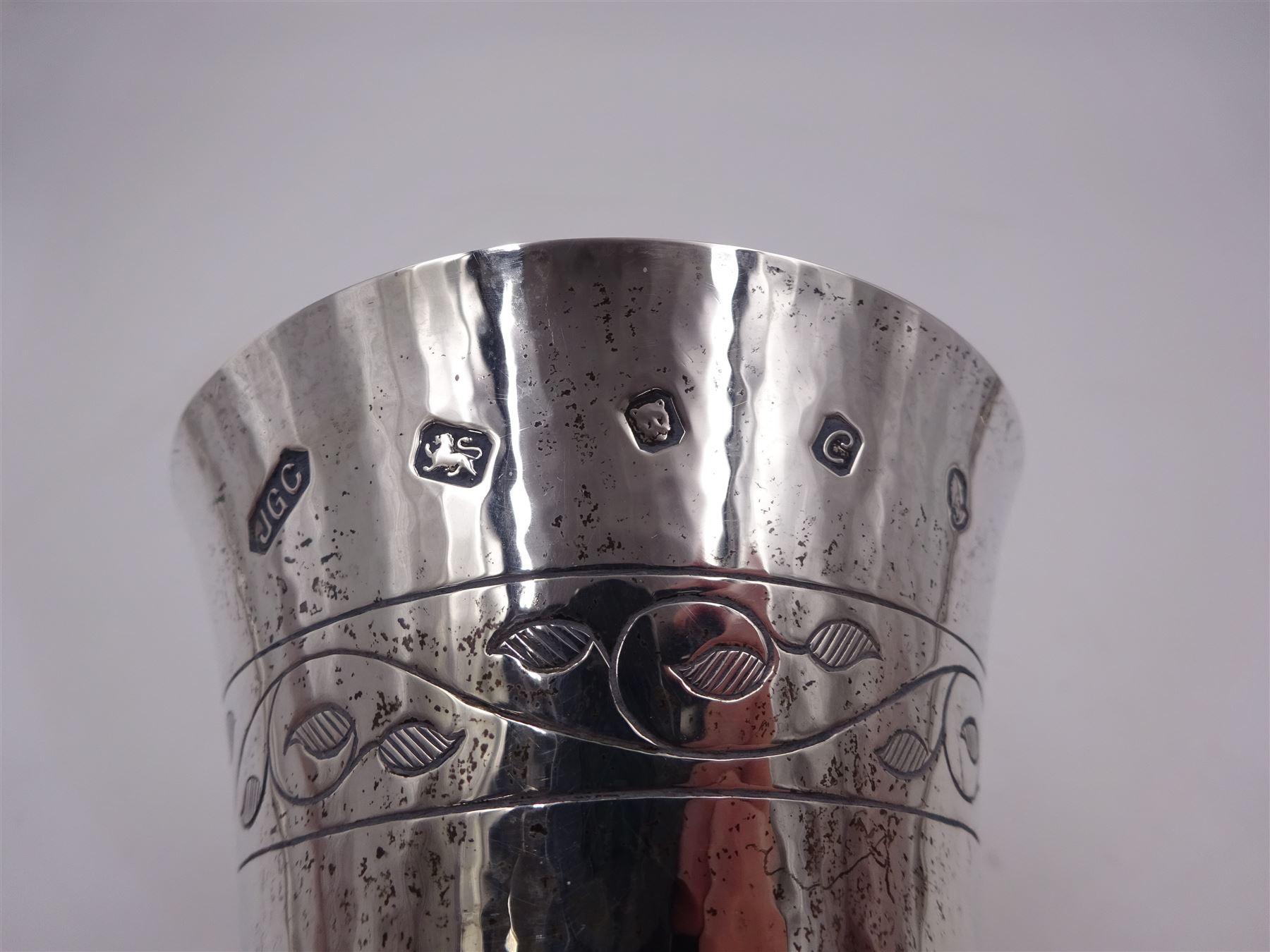 Modern limited edition silver goblet, a replica of the original silver chalice of Lincoln Cathedral, with hand planished decoration, and engraved band of laurel leaves to bowl, with gilt interior, upon waisted stem and circular stepped foot, no. 144/200, hallmarked John Cussell, London 1977, H15cm
