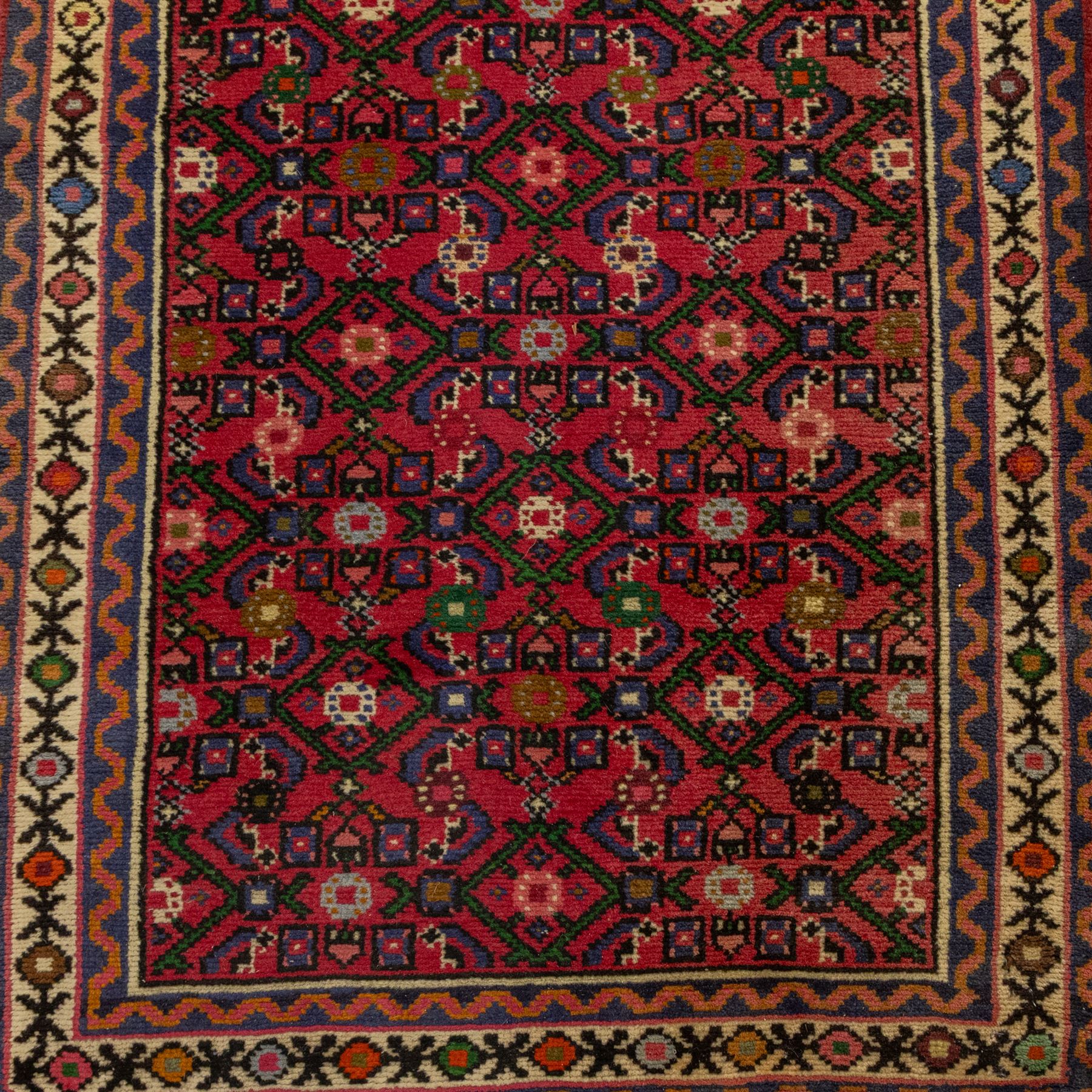 North West Persian runner, red field decorated with repeating herati motifs and small flowerheads, enclosed by cream main border with stylised floral motifs and narrow guard borders, fringed ends