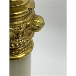 Gilt brass oil lamp, the cast base modelled with putti and mask amidst foliate scrolls, upon two scroll and one paw feet, leading to a onyx column with gilt capital, supporting a part acanthus cast gilt holder with removable bass reservoir and burner, clear glass chimney, and Vaseline glass shade, overall H85cm
