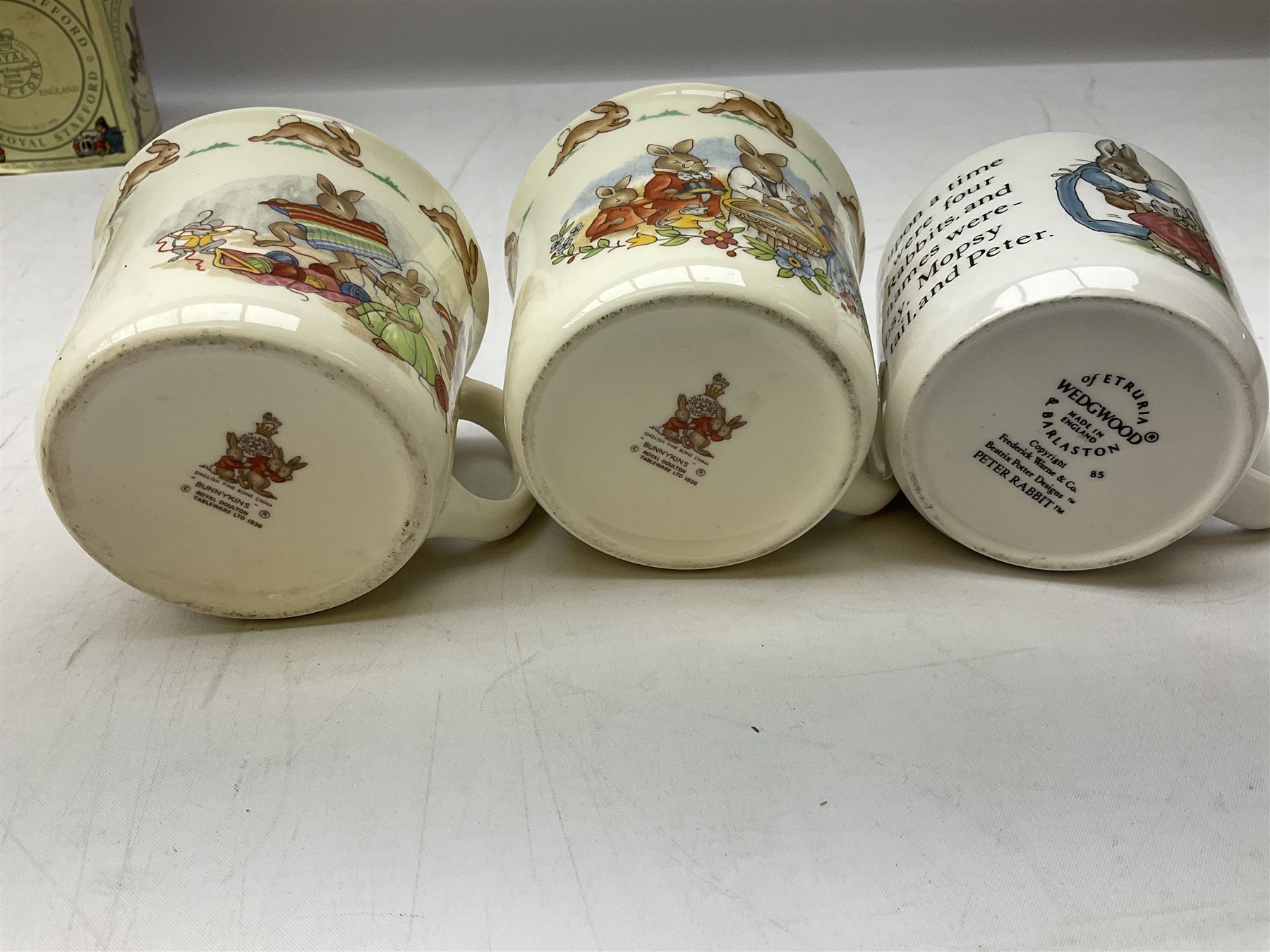 Royal Doulton Bunnykins nursery set in box and two cups, together with two Wedgwood Peter Rabbit mugs and Royal Staffordshire Noddy money box and cup (7)