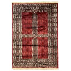 Tekke Ensi crimson ground rug, the quartered field decorated with candelabra motifs, multi-guarded border with repeating geometric hexagonal lozenges in blue and ivory