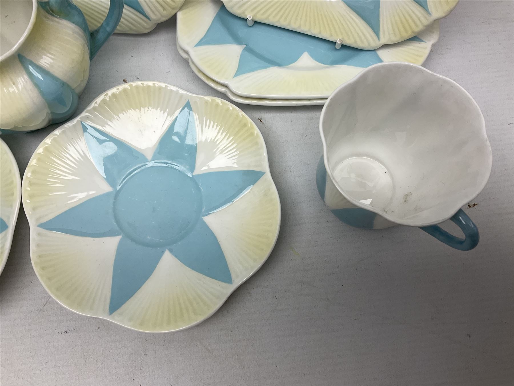 Shelley Dainty pattern tea wares, of lobed form with blue star decoration on merging white and yellow ground, comprising five teacups, five saucers, six tea plates, milk jug and cake plate, all with printed green mark beneath, some with painted pattern no 11770