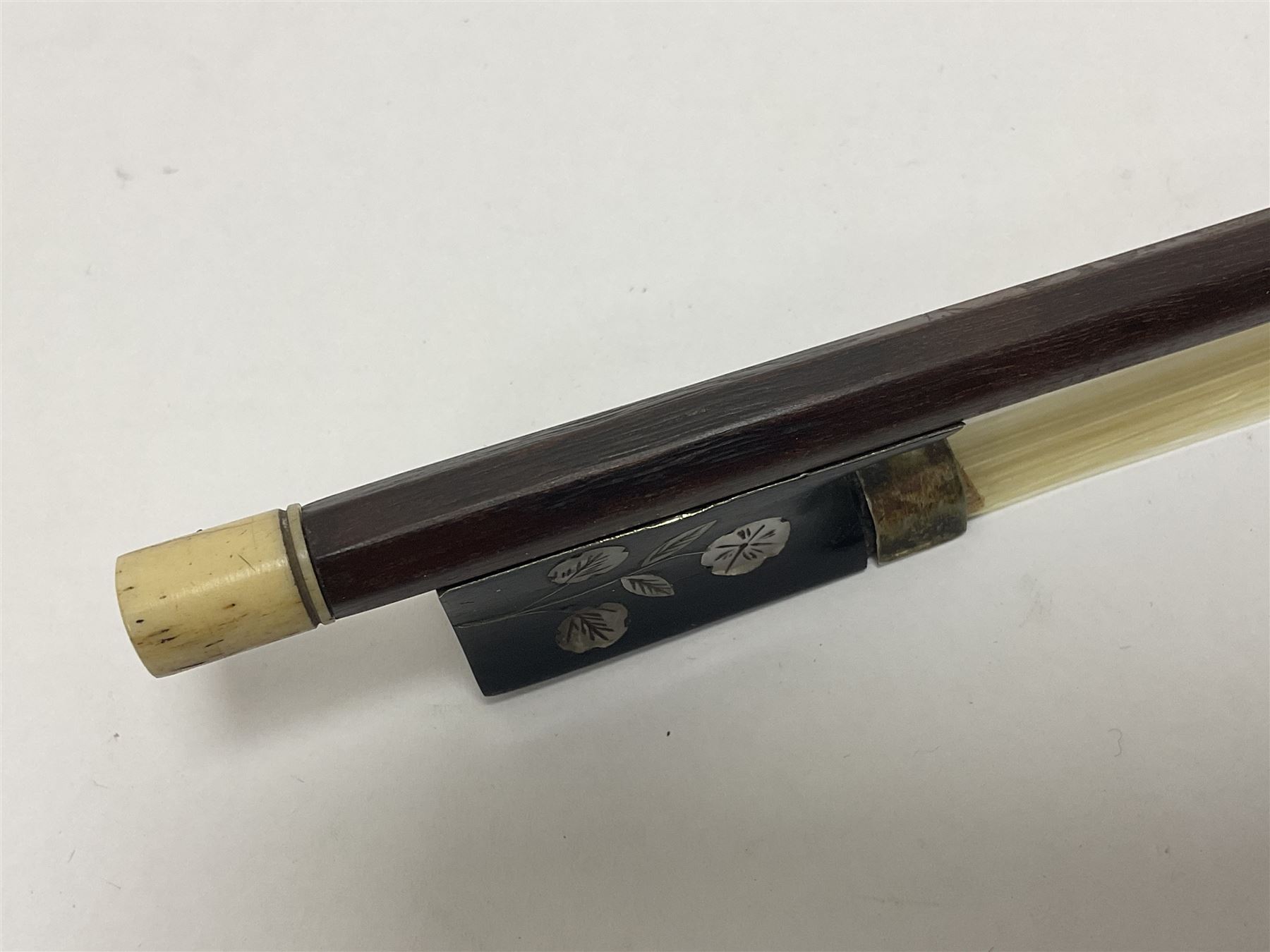 19th century wooden violin bow with a decorative mother of pearl inlay depicting flowers to the frog, with a bone adjuster screw