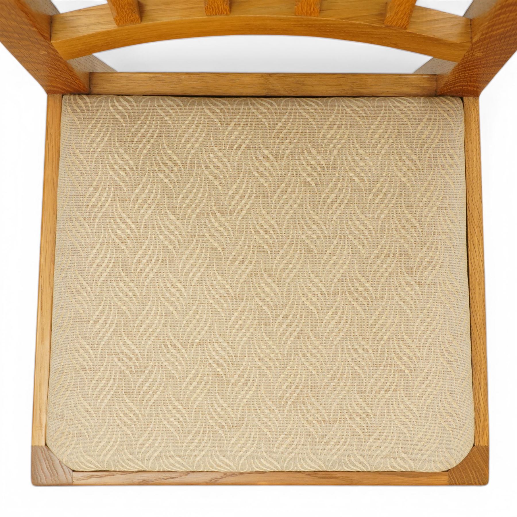 Knightman - eight oak dining chairs, the rectangular back with square section lattice splat enclosed by straight stiles and top rail, drop in upholstered seat in pale patterned fabric, raised on square section legs with chamfered detailing united by stretchers, with carved knight signature, by Horace Knight of Thirsk