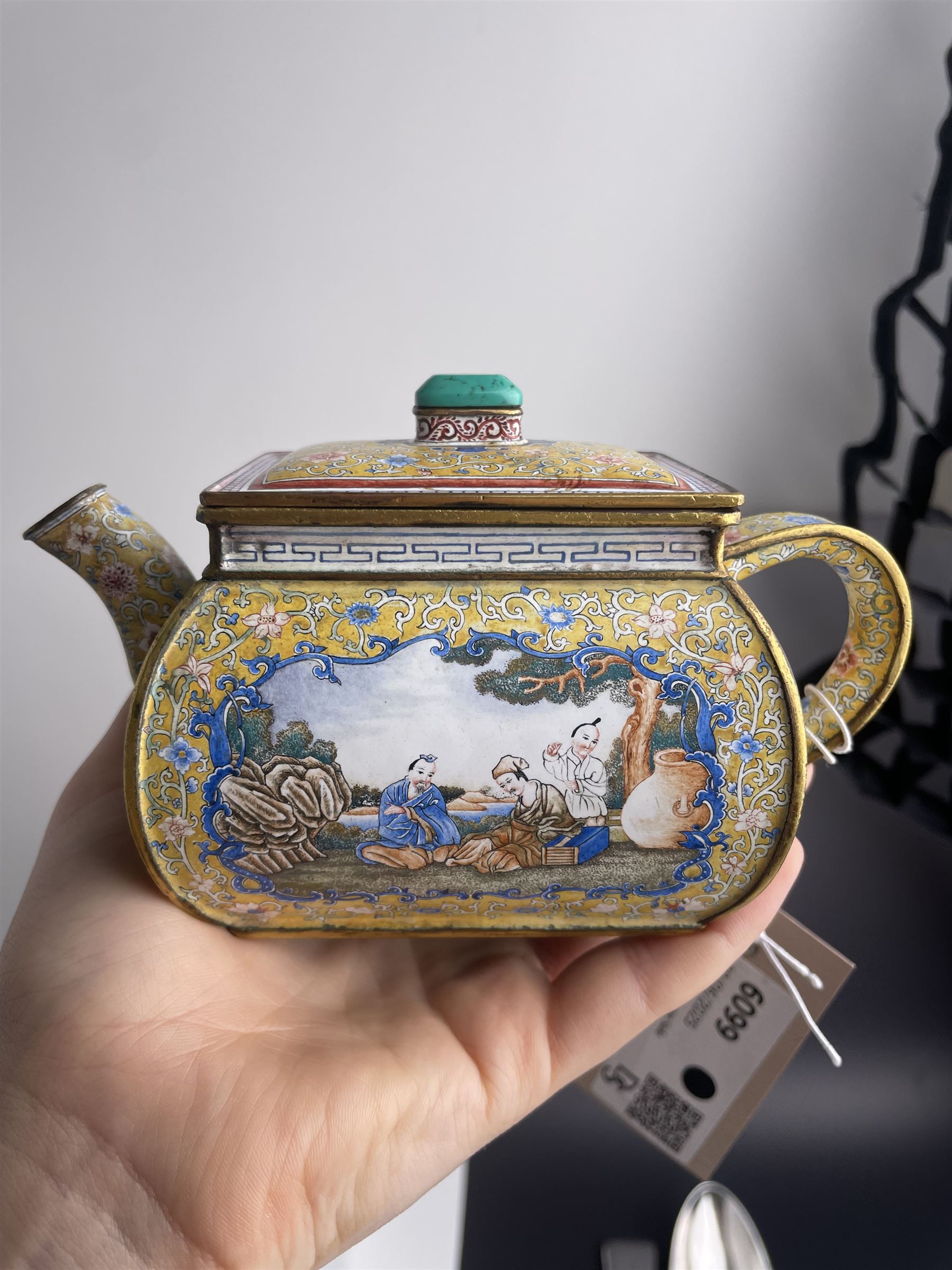 Chinese Qianlong enamel bombé shaped teapot, decorated with scenes of scholars examining a scroll and drinking on a yellow ground with various traditional floral and foliate motifs, the painted scene framed within trailing blue vine border, with Qianlong marks to base L15cm