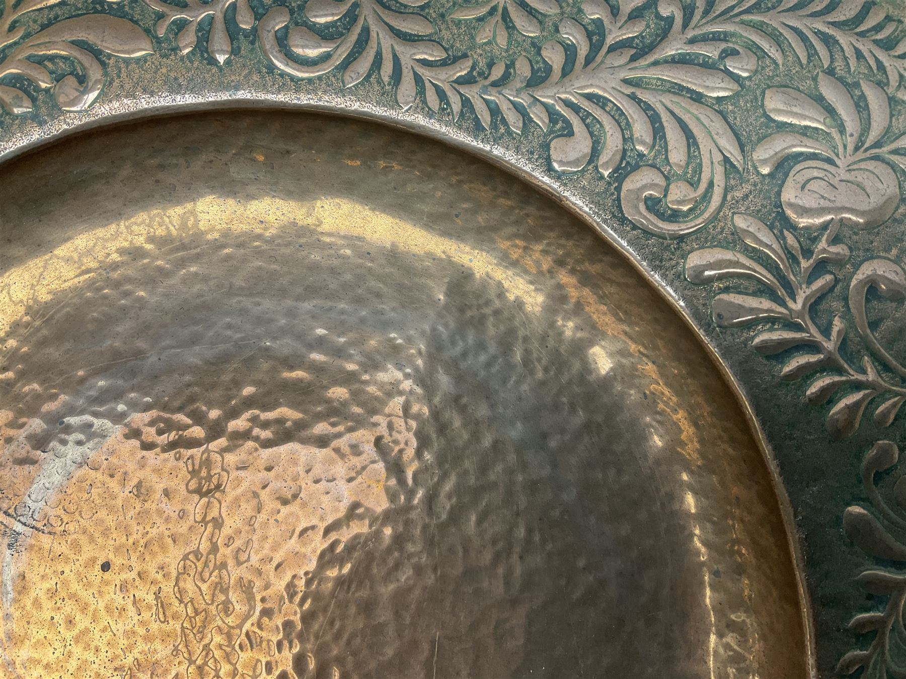 Arts and Crafts Keswick School of Industrial Arts copper charger, decorated with planished centre and repousse scrolling foliate tendrils to rim, D44cm