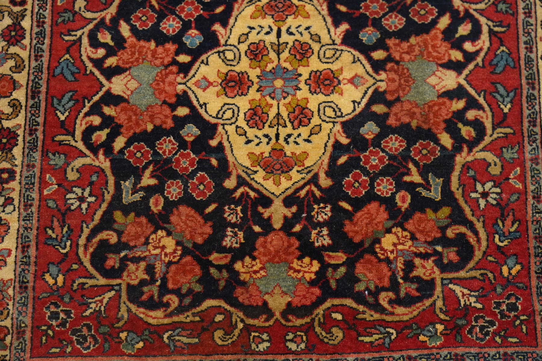 Collection of four Persian rugs, comprising a Saraband ivory ground rug with all-over boteh field and multiple borders; a crimson ground Hamadan type rug with all-over stylised floral and geometric motifs; a floral medallion prayer rug with dark field and ivory spandrels; and a Hamadan peach ground rug with repeating stylised flowering plants and dark multiple borders, largest 83cm x 142cm