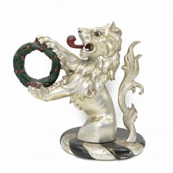 20th century carved silvered wood crest of a lion holding a wreath, possibly a horse tether, on circular wooden plinth, H37cm 