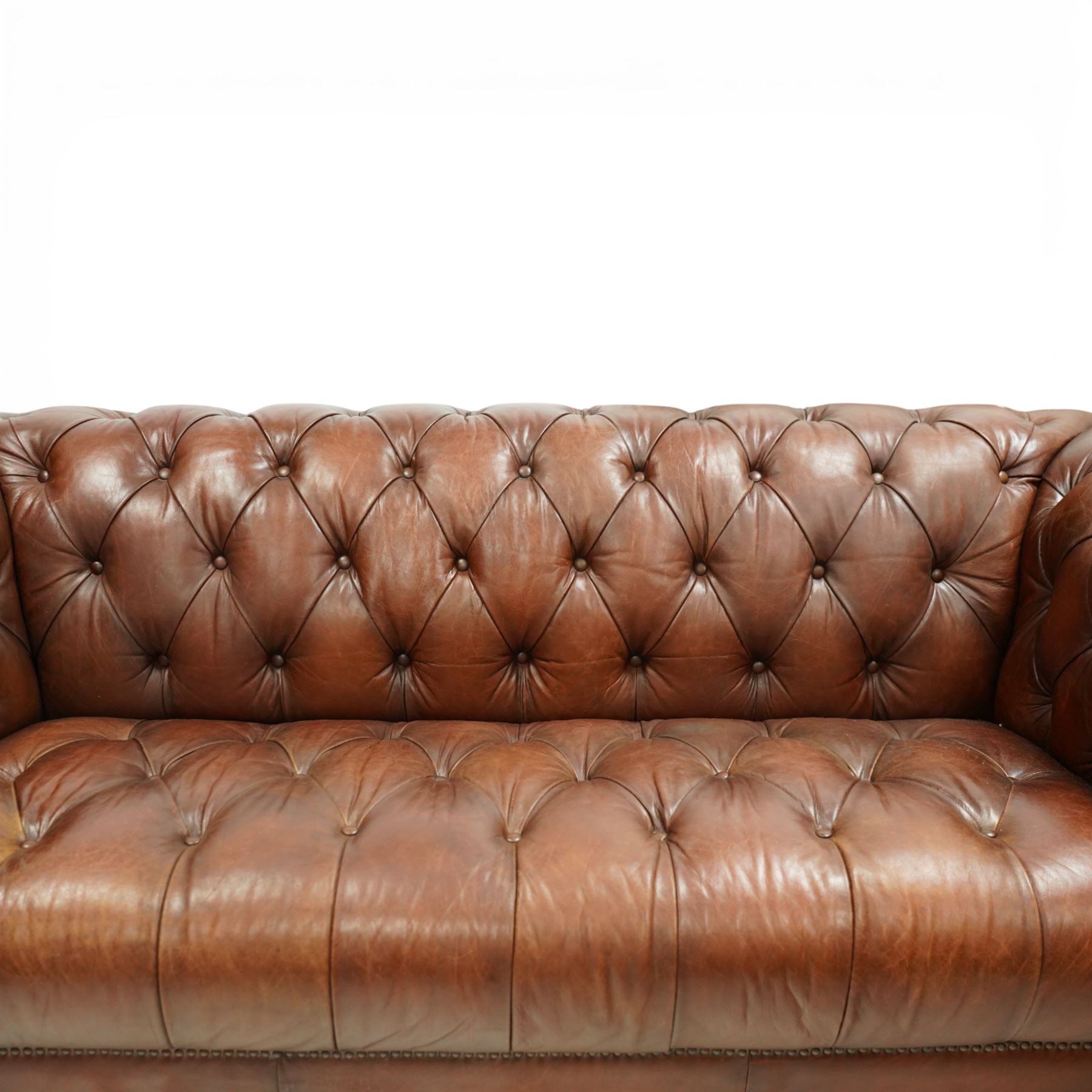 Ullswater - late 20th century brown leather chesterfield sofa, deep button tufted back, arms and seat, classic rolled arm form with studded borders to the arms and base, raised on turned feet with castors