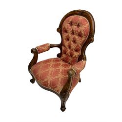 Victorian walnut framed armchair, cresting rail carved with scrolling foliate decoration, scrolled arm terminals over cabriole supports, upholstered in buttoned coral and ivory Damask fabric with overstuffed seat