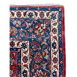 Persian red ground rug, the central ivory pole medallion surrounded by scrolling interlaced foliate patterns, the guarded indigo border with repeating palmette motifs