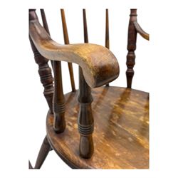 Late 19th century elm and beech Windsor rocking chair, with shaped top rail over turned spindles and curved arms, circular seat raised on turned legs united by stretcher on rockers