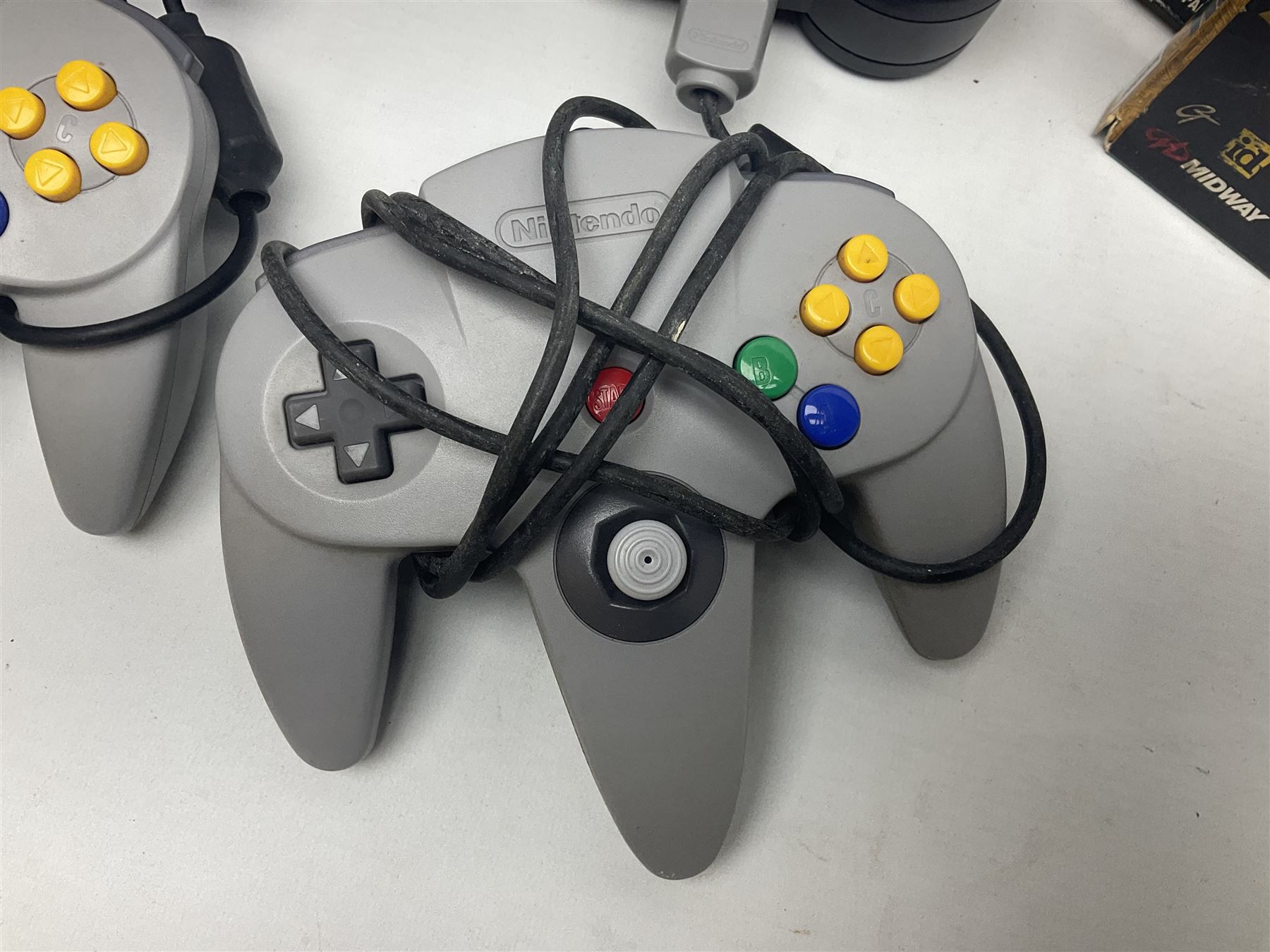 Nintendo 64 console, two controllers, games and accessories. Accessories to include the ‘Tremorpak’ and ‘Spook’ 2 Phono plugs and a S-VHS plug with adapter, both in original boxes. Games to include ‘Golden Eye 007’, ‘Doom 64’, ‘Killer Instinct Gold’, ‘Tetrisphere’, ‘F-1 World Grand Prix’, ‘Pilotwings 64’ and ‘Lylatwars’ with ‘Rumble Pak’, all with original boxes and instruction manuals. ‘Star Wars Episode I Racer’ game cartridge in Shadows of the Empire box. 