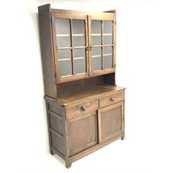 Vintage oak dresser raised back with two glazed doors enclosing shelves above two sliding base drawers 