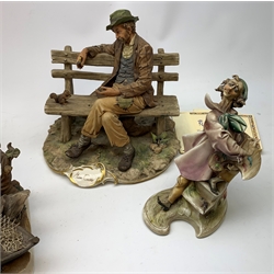 A group of four Capodimonte figurines, comprising The Fisherman, Tramp on Bench, each with accompanying certificate, and two others, one modelled as two clowns leaning against a broken drum, the other modelled as a painter.