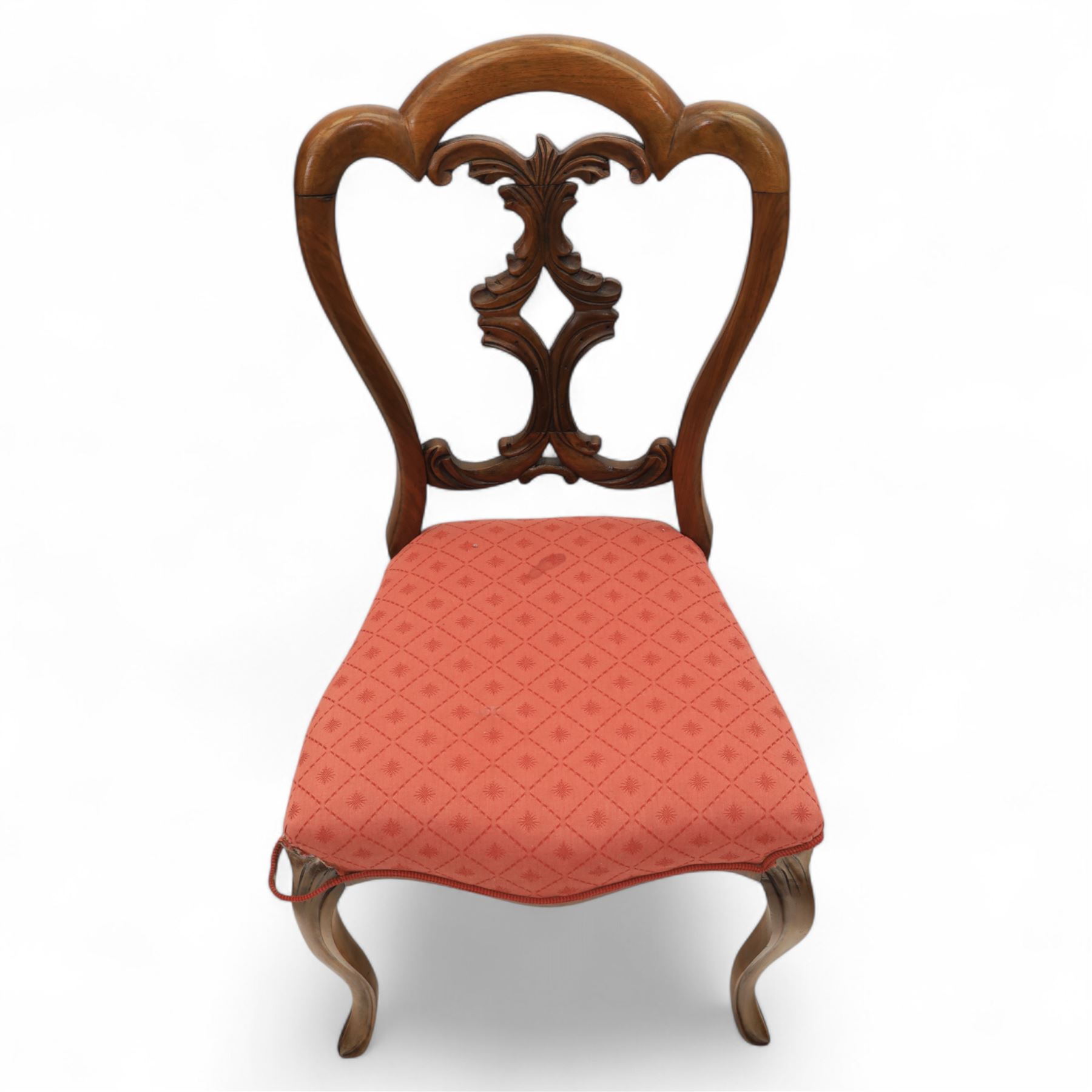 Set of four Victorian walnut balloon back chairs, with a carved and pierced back splat with foliate scrolls, serpentine seat upholstered in a diamond pattern fabric, raised on cabriole legs 