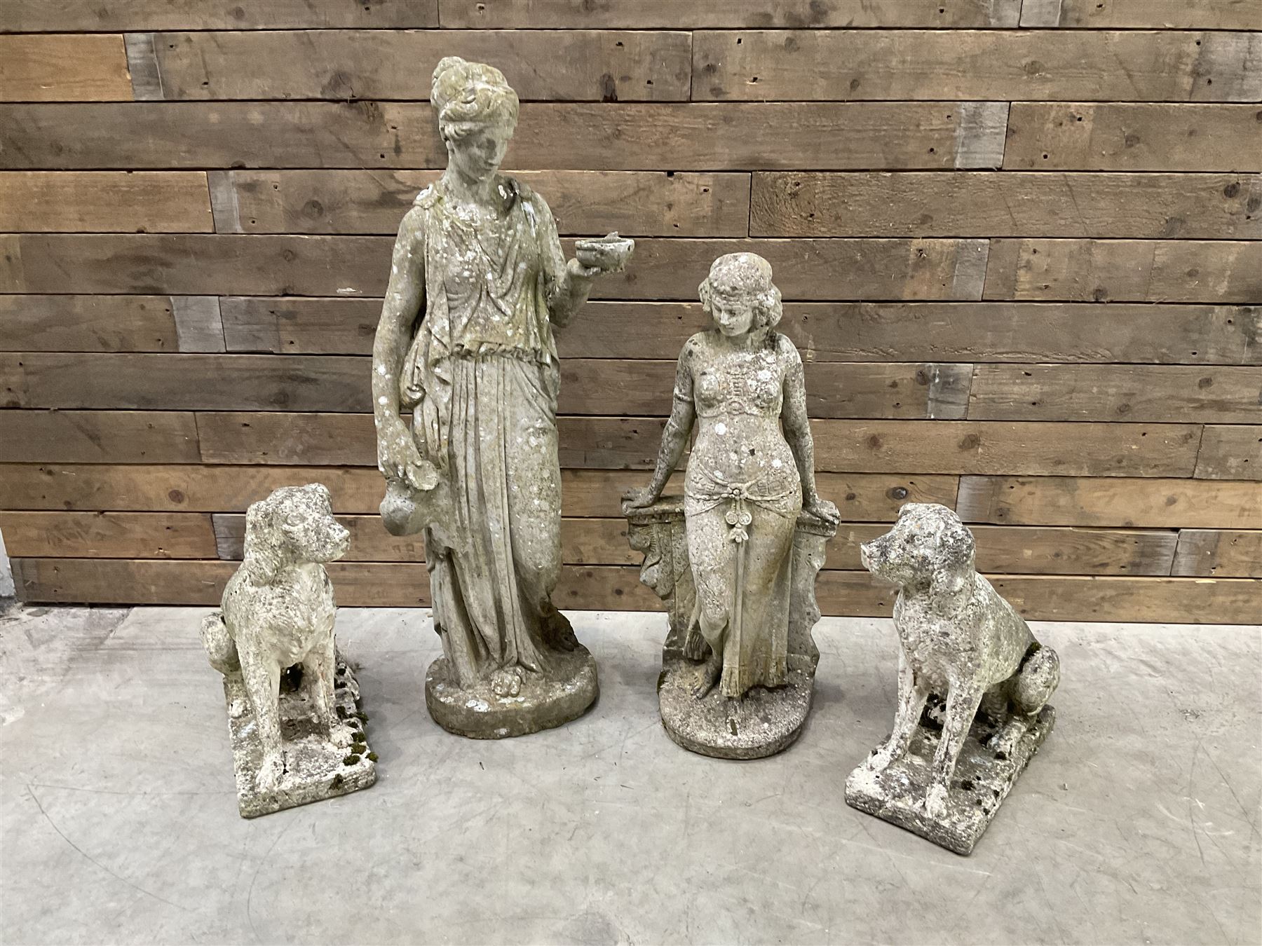 Pair of cast stone garden dogs and 2 female figures,