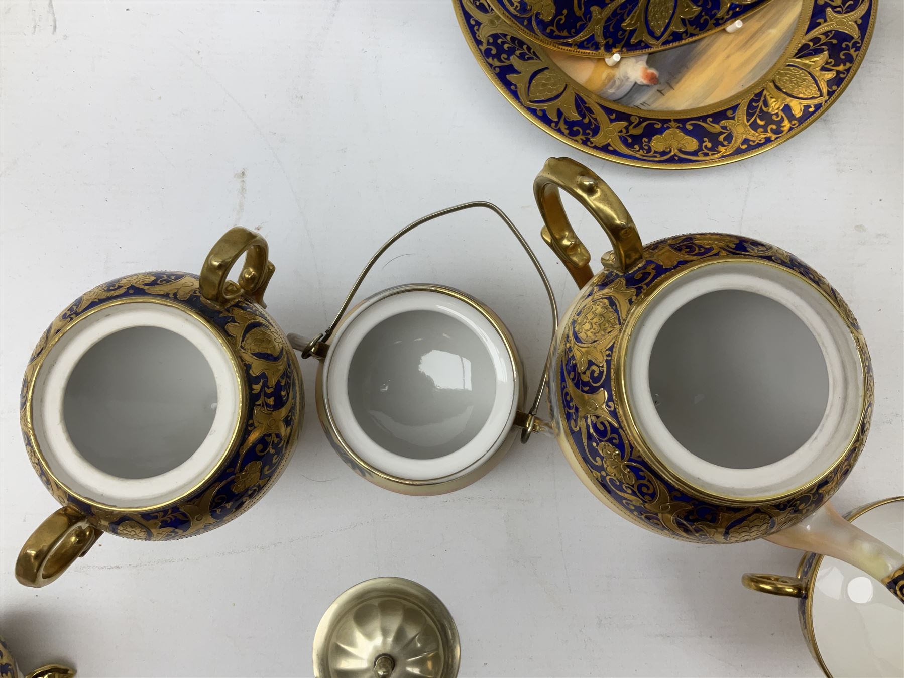 Noritake tea service for four, decorated with desert camel scene with blue border and gilding, comprising four teacups and saucers, four side plates, lidded sucrier, teapot and jug, together with twin handled pedestal bowl etc (19 pcs) 