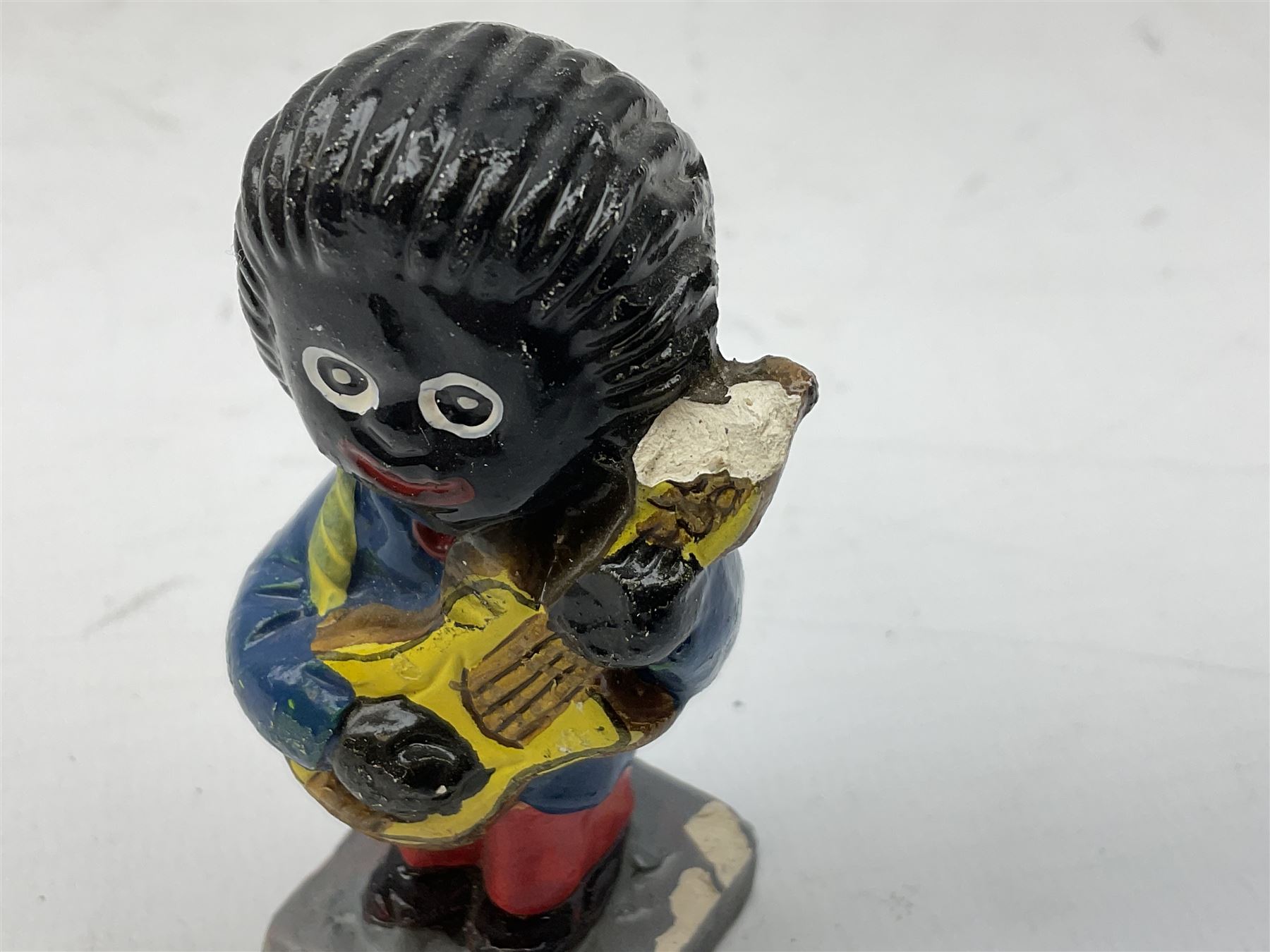 Robinson Jam plaster Golly band, including drummer and singer, H7.5cm

Originally handmade by mothers in Africa for their children from old fabric and cloth, the golly doll was adopted as the mascot and trademark for the Robertson's confectionery brand around 1910 after the company's founder John Robertson visited the US and noticed children playing with them. Robertson's Gollies have been collected by people across the UK and around the world for generations but garnered a contentious image in the 1980s because of links to racism. The trademark was removed from Robertson's branding in 2001.