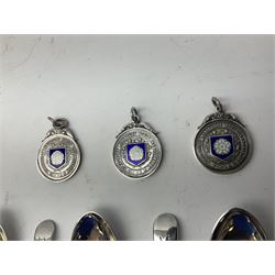 Set of three Yorkshire Miniature Rifle Association hallmarked silver and enamel fob medals, Birmingham 1925, 1926 & 1929; together with six silver plated coffee spoons each engraved with crossed rifles to the terminal (9)