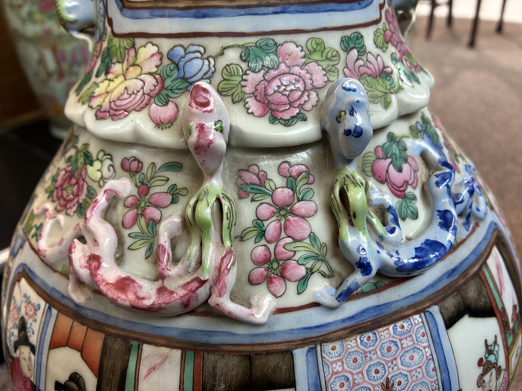 Large pair of 19th century Cantonese famille rose vases, each painted with various courtly scenes, including a display of warriors fighting on horseback before an official and his attendants, double Buddhist lion handles and applied at the shoulders with chilong, the lower band painted with Greek key motif, H58cm (2)