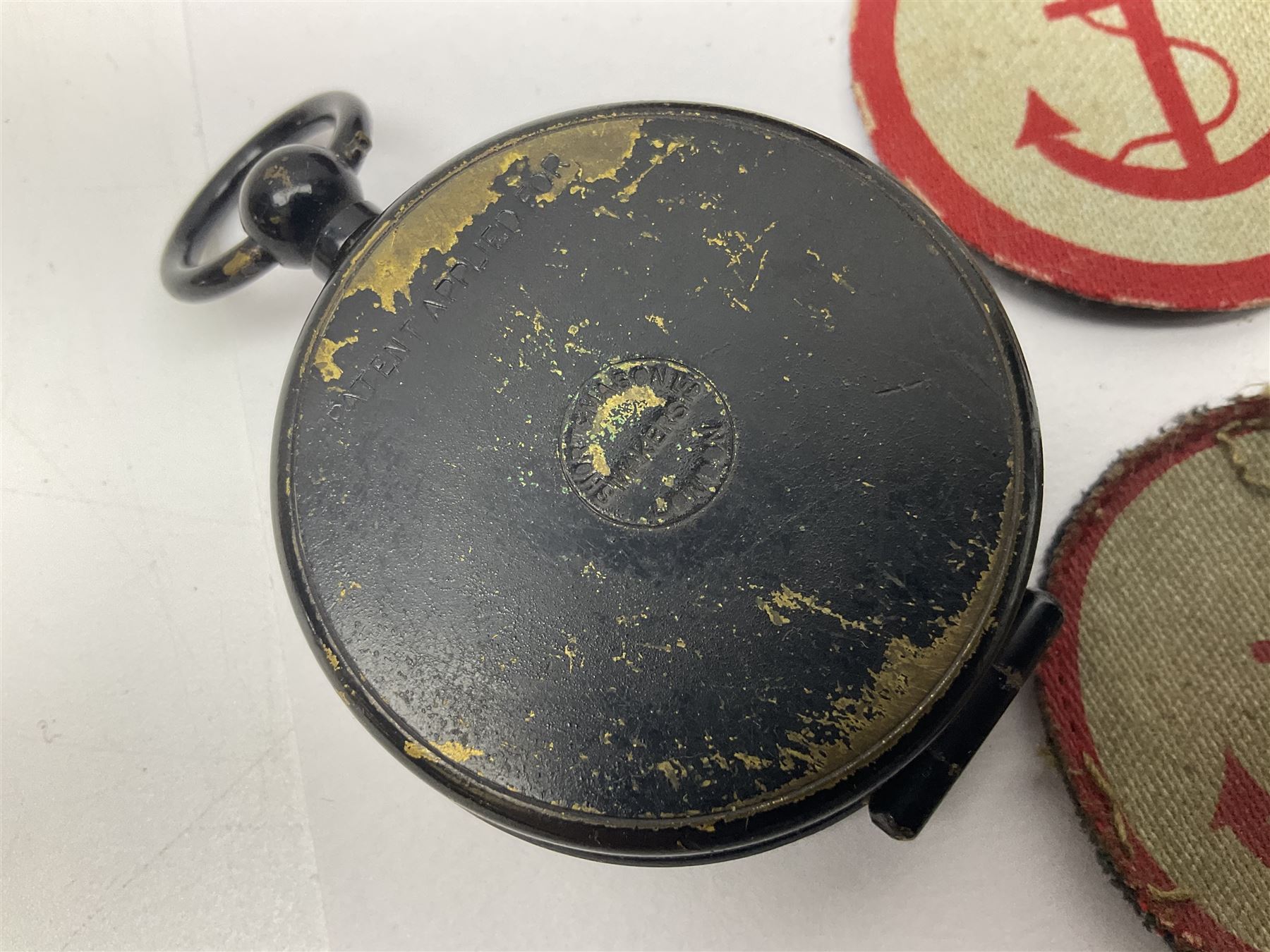 WW1 Short & Mason Ltd 'The Magnapole' black japanned brass field compass in leather carrying case; WW1 trench art paper knife inscribed Dixmude; and small quantity of cloth badges etc