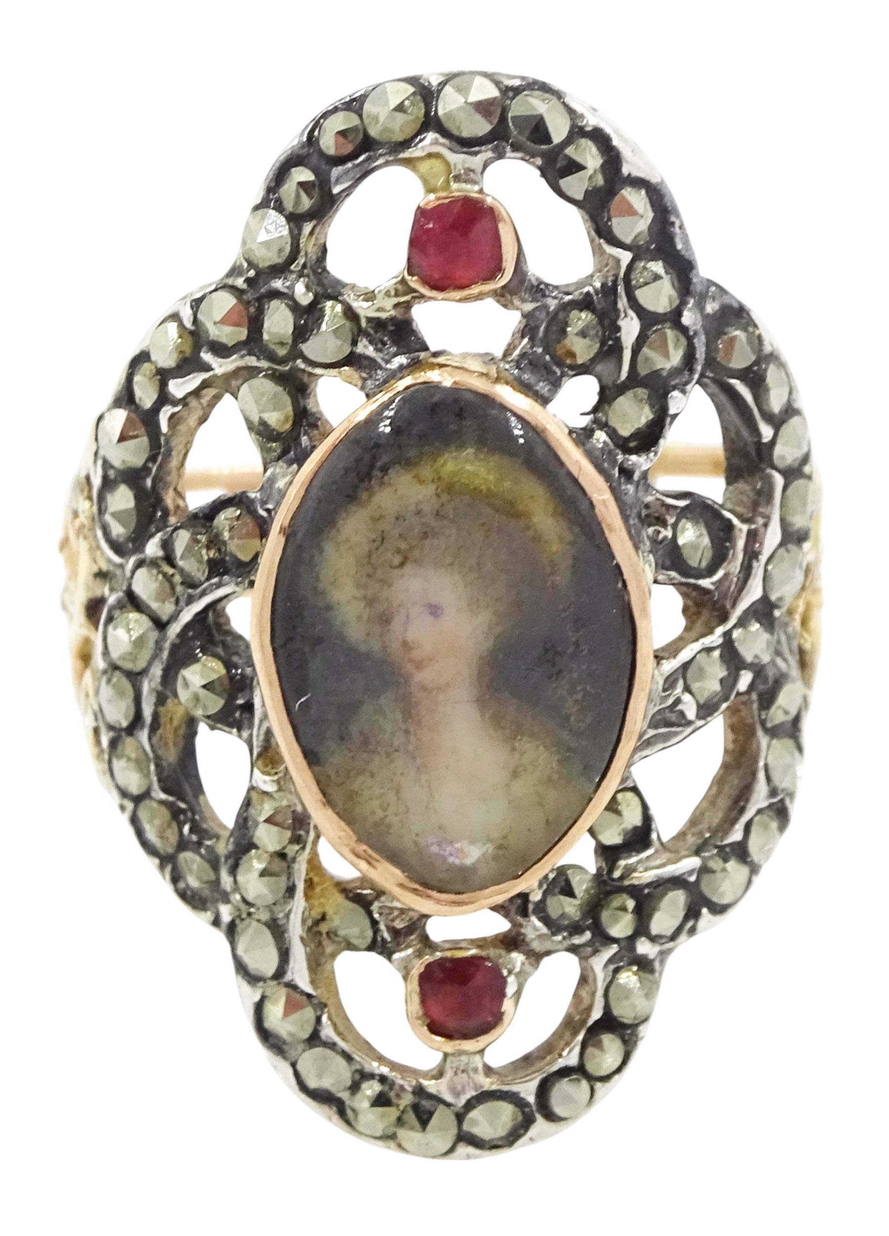 19th century gold and silver marcasite portrait ring, set with an oval miniature of a woman on ivory, under a glazed panel, with a marcasite and red stone set crossover surround, with pierced gold shoulders and reeded shank. This lot has been registered for sale under Section 10 of the APHA Ivory Act